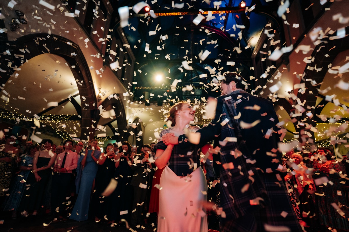 Robyn and James share a dance beneath falling confetti during their evening wedding reception at Òran Mór in Glasgow.