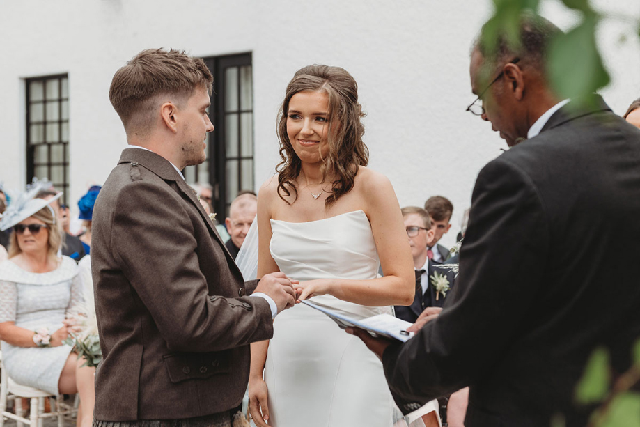 Bride and groom hold hands during the ceremony