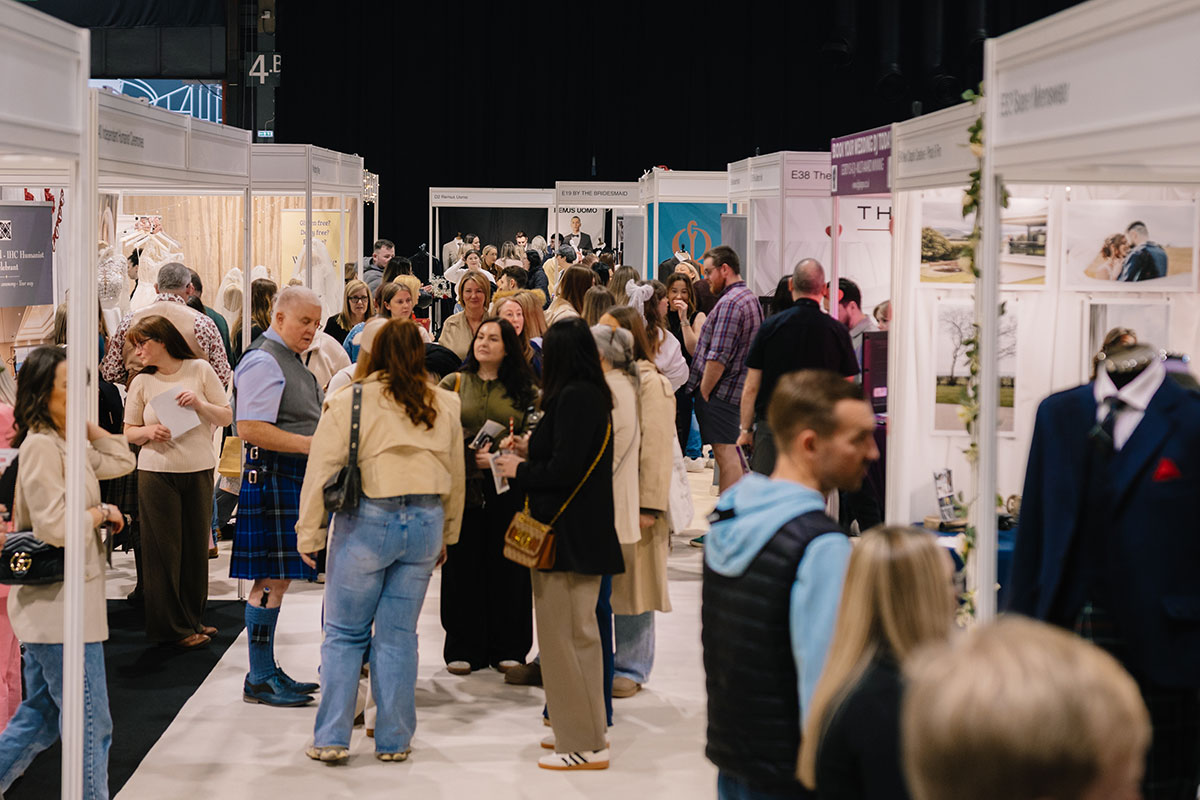 Couples and visitors browsing wedding supplier stands inside the busy exhibition hall at The Scottish Wedding Show.