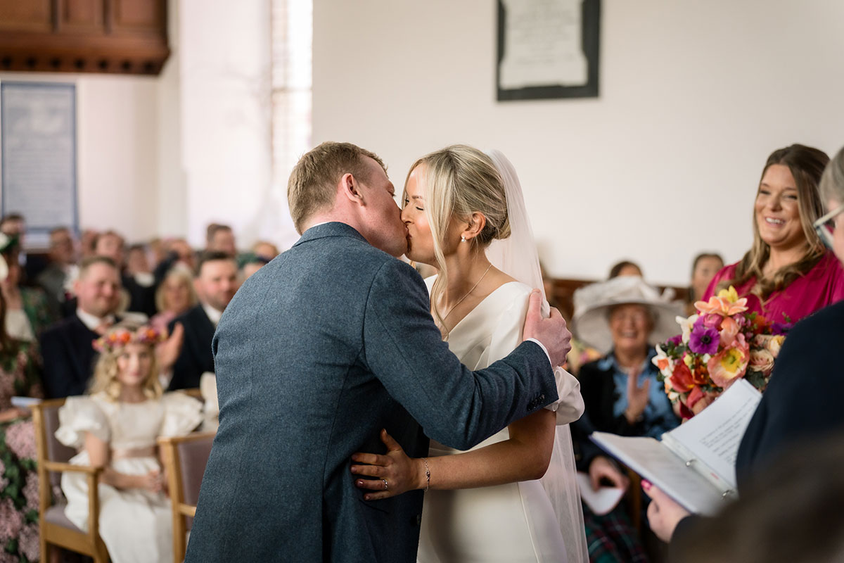 bride and groom share first married kiss at achnagairn castle