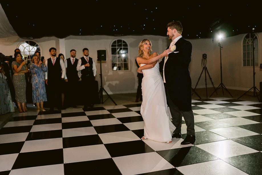 A bride an groom dancing on a checkered floor in the permanent marquee at Mar Hall.