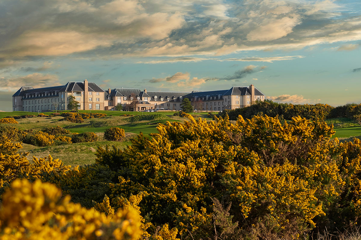 Fairmont St Andrews hotel exterior surrounded by gorse and rolling countryside at golden hour