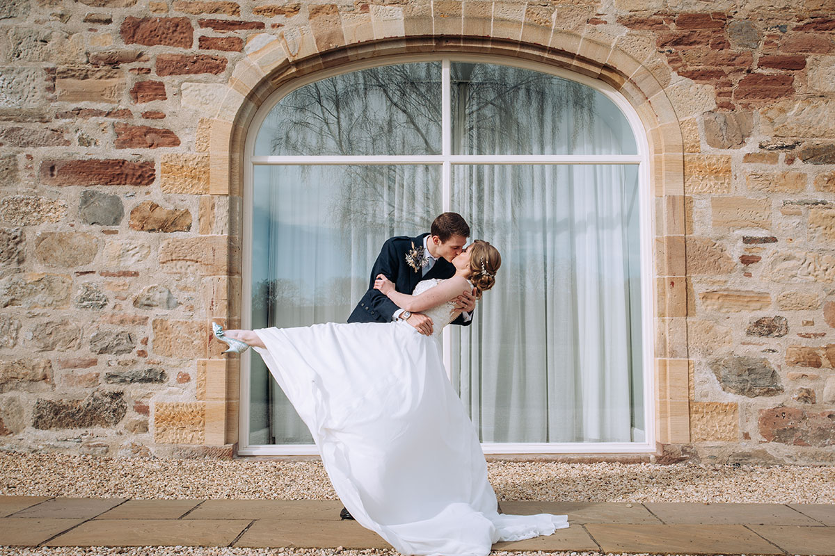 Bride and groom kiss outside Newhall Mains