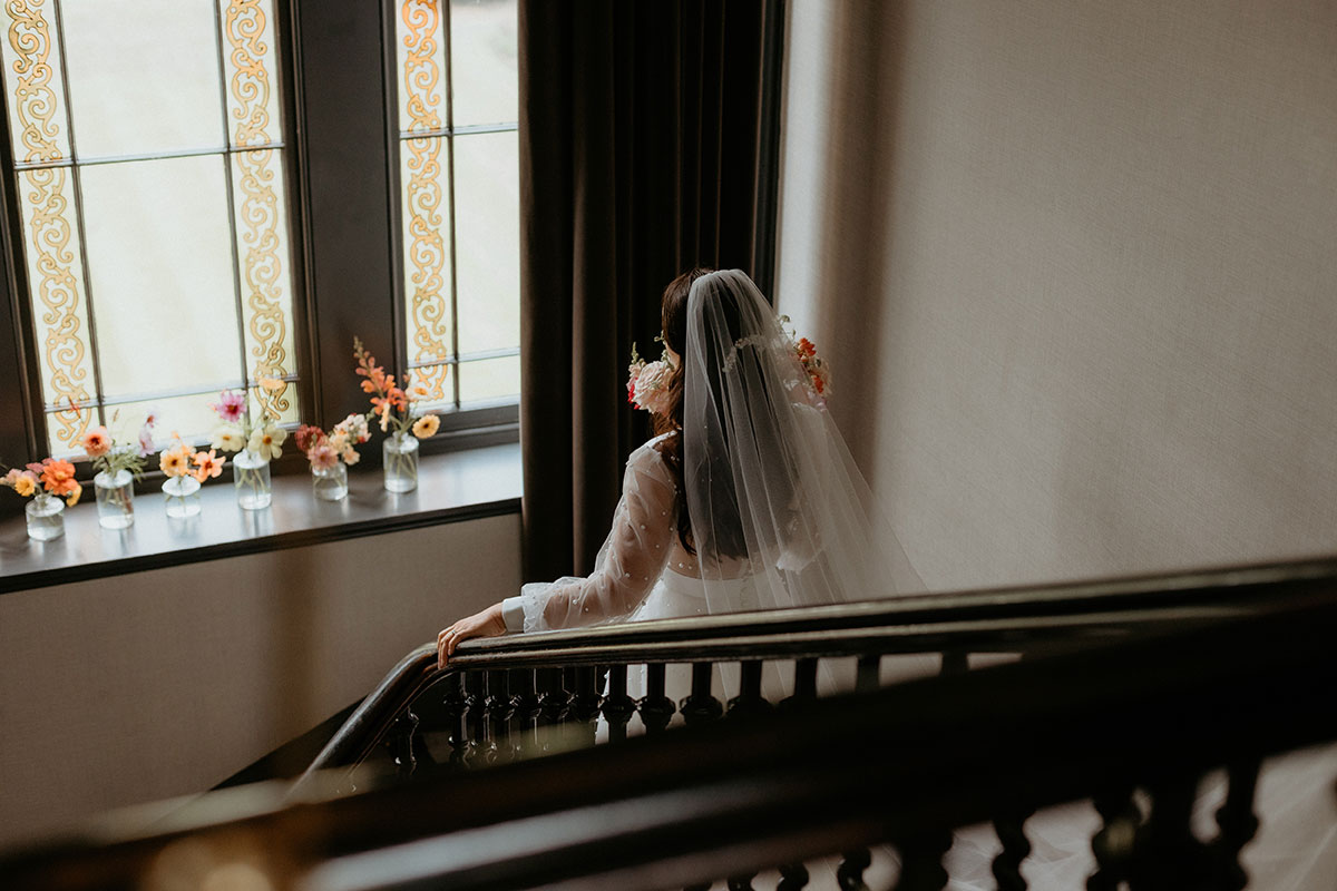 a bride walking down a set of stairs at Carlowrie Castle
