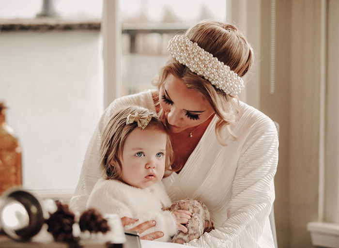 a bride looking down to a toddler sitting on her lap