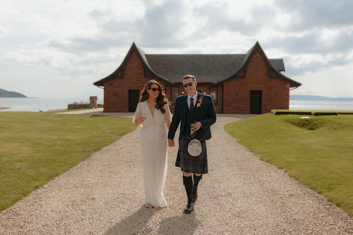 Couple walking along the coastal path at Dougarie Boathouse on the Isle of Arran with sea views behind.