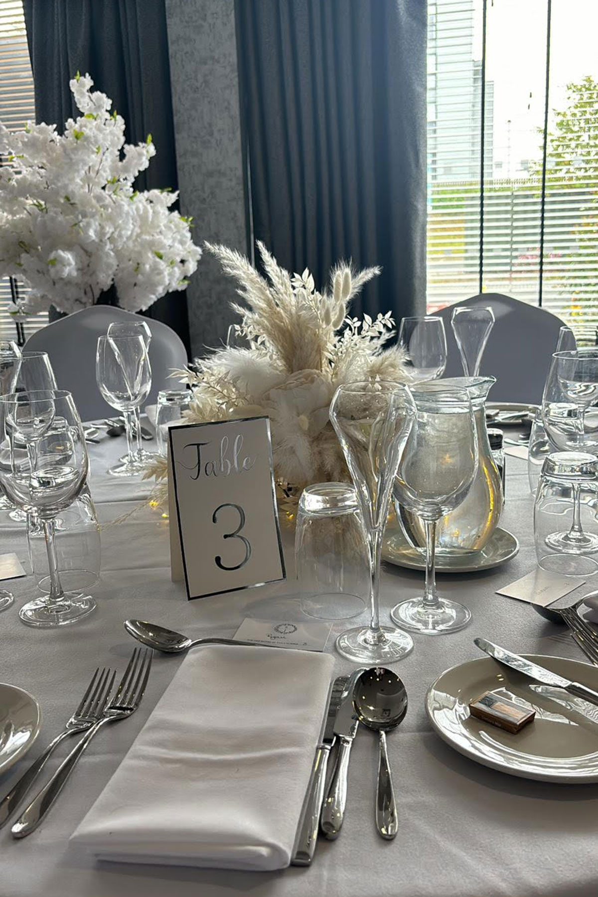 Elegant wedding breakfast table styling with neutral floral centrepiece, glassware and place settings at a Scottish wedding venue