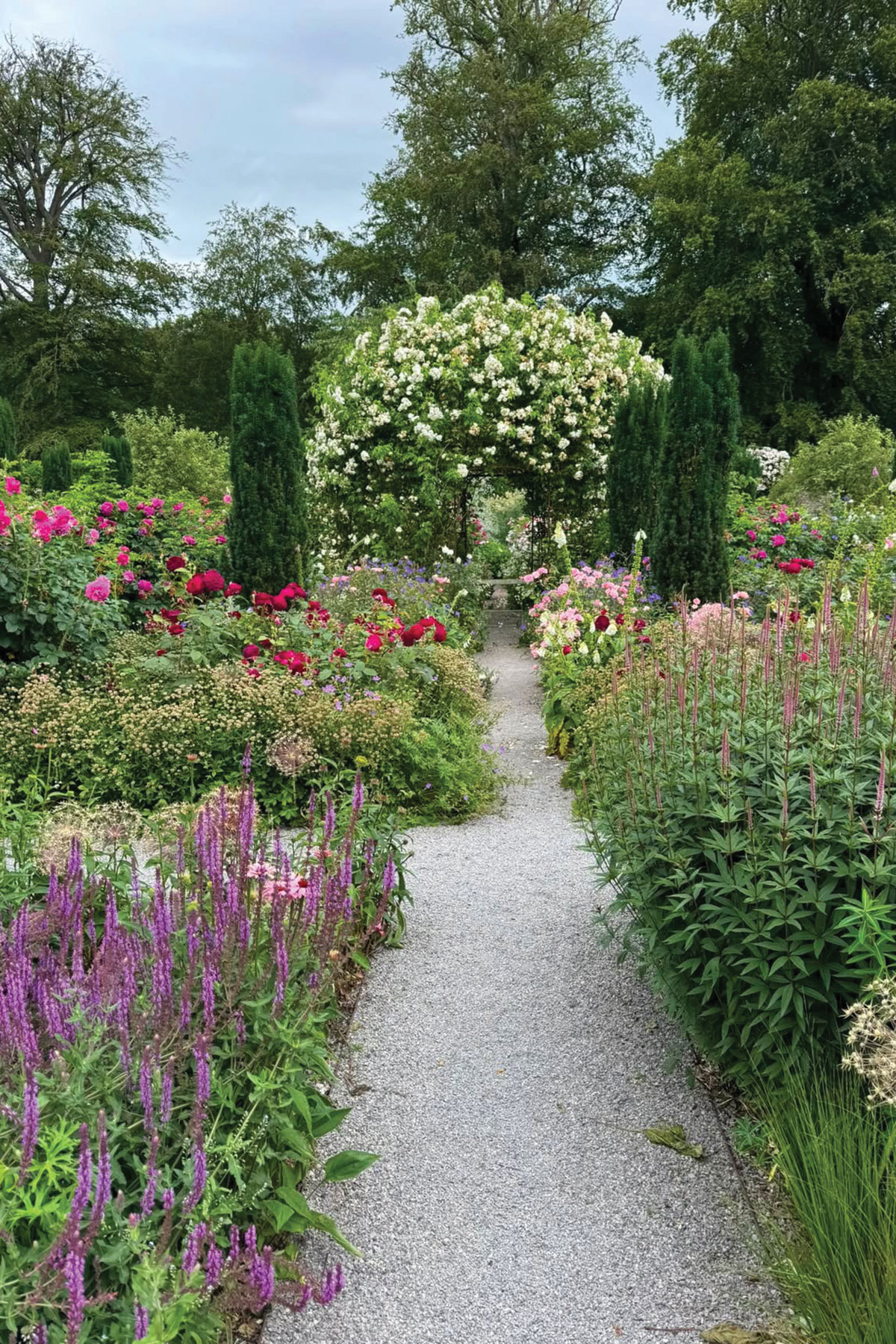 Colourful rose garden with flowering arch and gravel pathways at a country house wedding venue in North Yorkshire