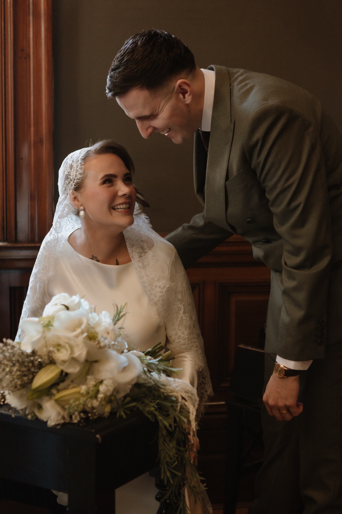 Newlyweds laughing together after signing the wedding register at 23 Montrose Street in Glasgow.