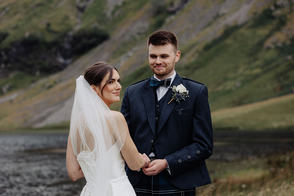 Couple holding hands by the loch