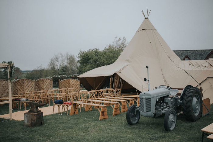 Teepee and chairs set up beside a tractor