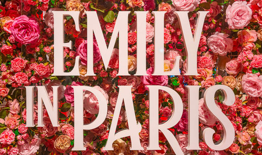 'Emily in Paris' signage in front of a wall of pink and red flowers