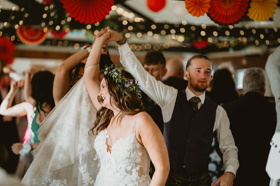 The groom spins the bride on the dancefloor