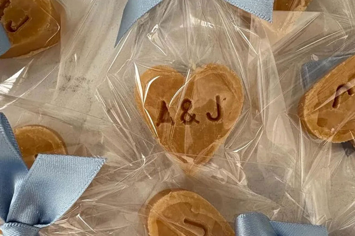 Heart-shaped tablet wedding favours wrapped in clear packaging with blue ribbon