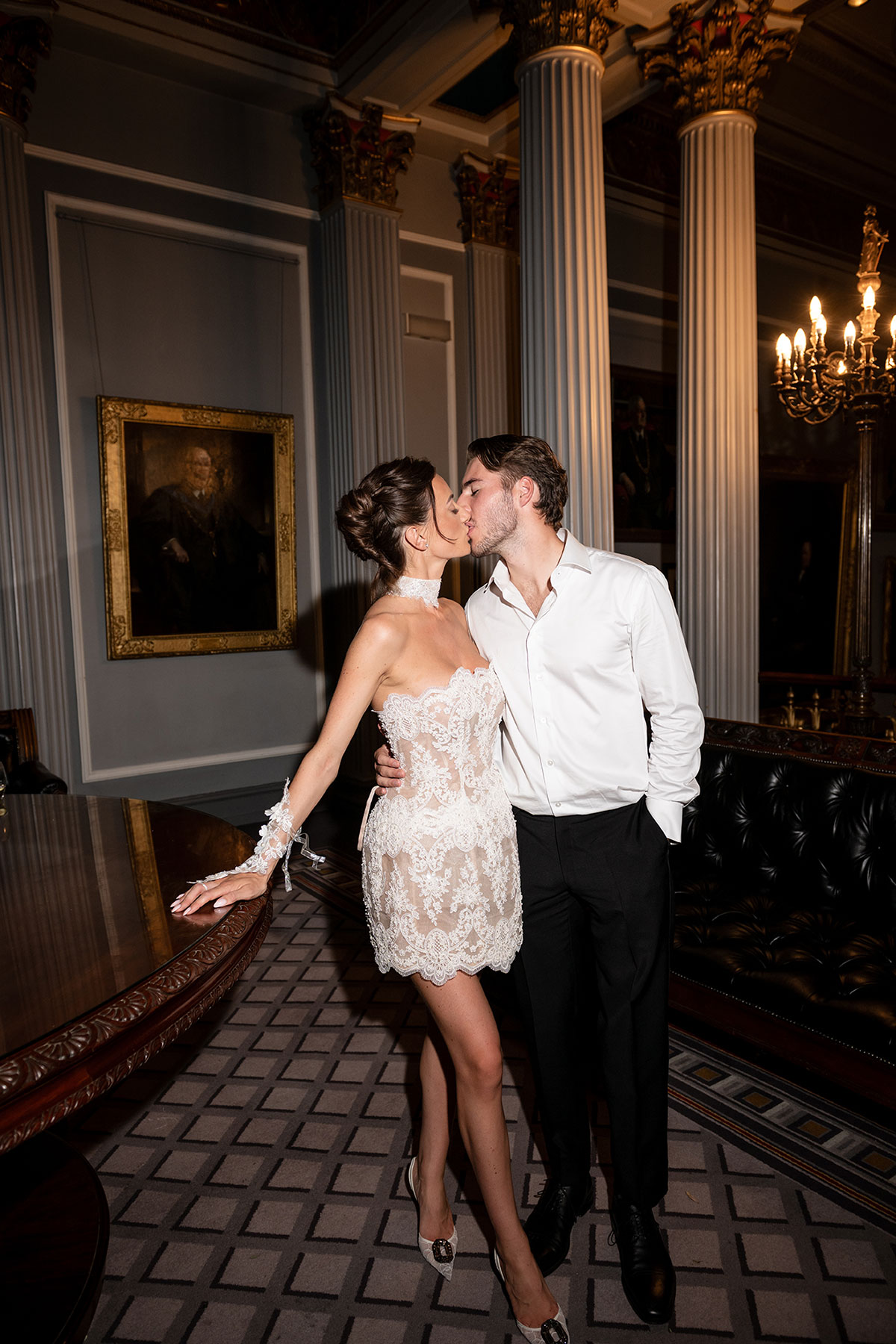Bride in embroidered mini dress kissing groom in evening look at The Signet Library wedding Edinburgh