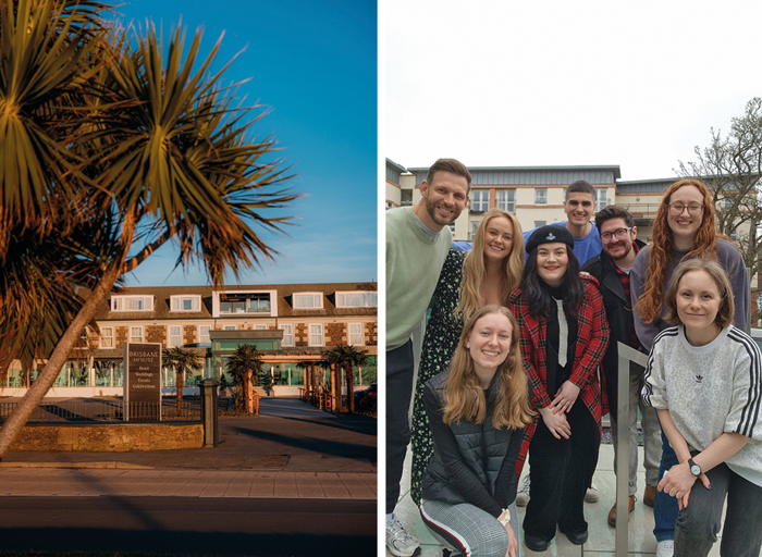 On the left is a two storey building withpalm trees in front of it, on the right a group of people gather together for a photo.