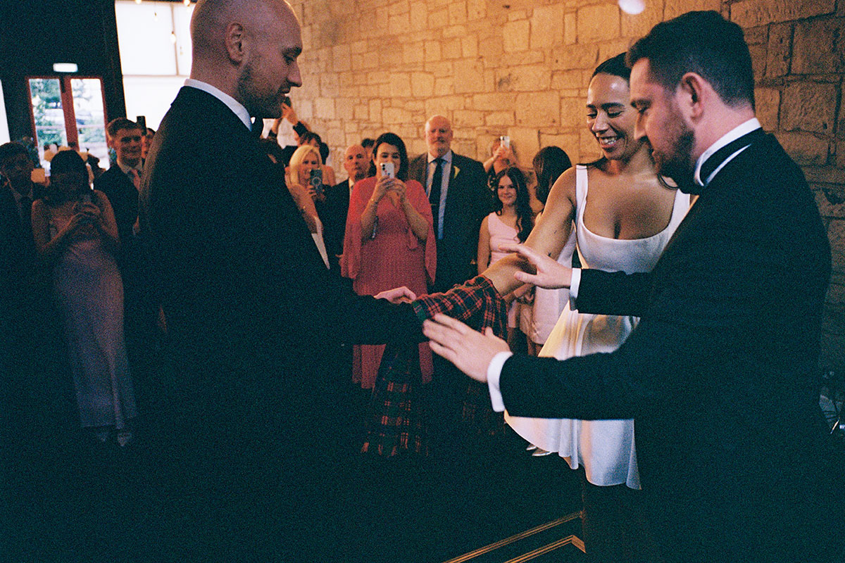 Bride and groom taking part in handfasting ceremony led by friend at The Haberdashery Glasgow wedding reception