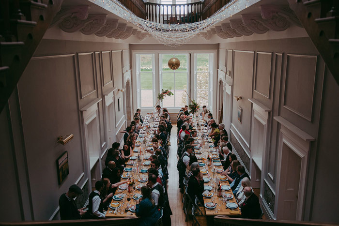 two long tables with people seated for dinner at Netherbyres House