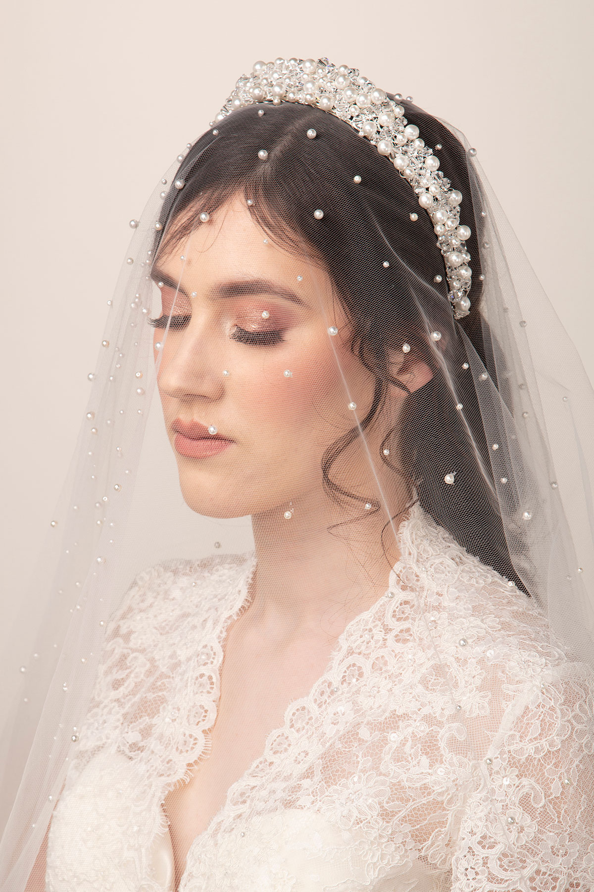 Bride wearing a pearl-detailed wedding veil with a coordinating pearl and crystal headpiece by Baba-C Designs.