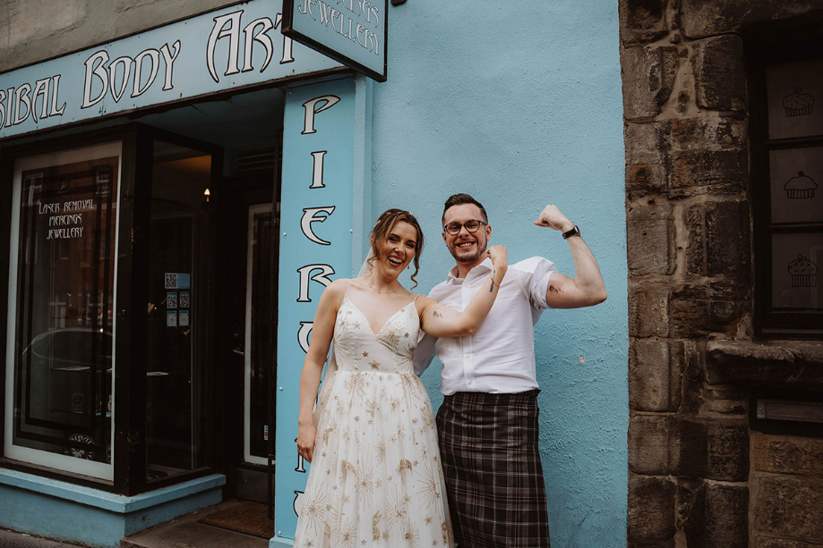 Bride and groom pose with their new tattoos outside tattoo parlour 