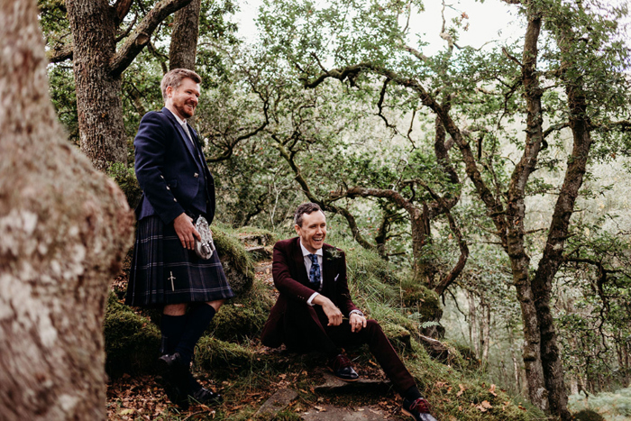 Two grooms laugh during outdoor couple portraits