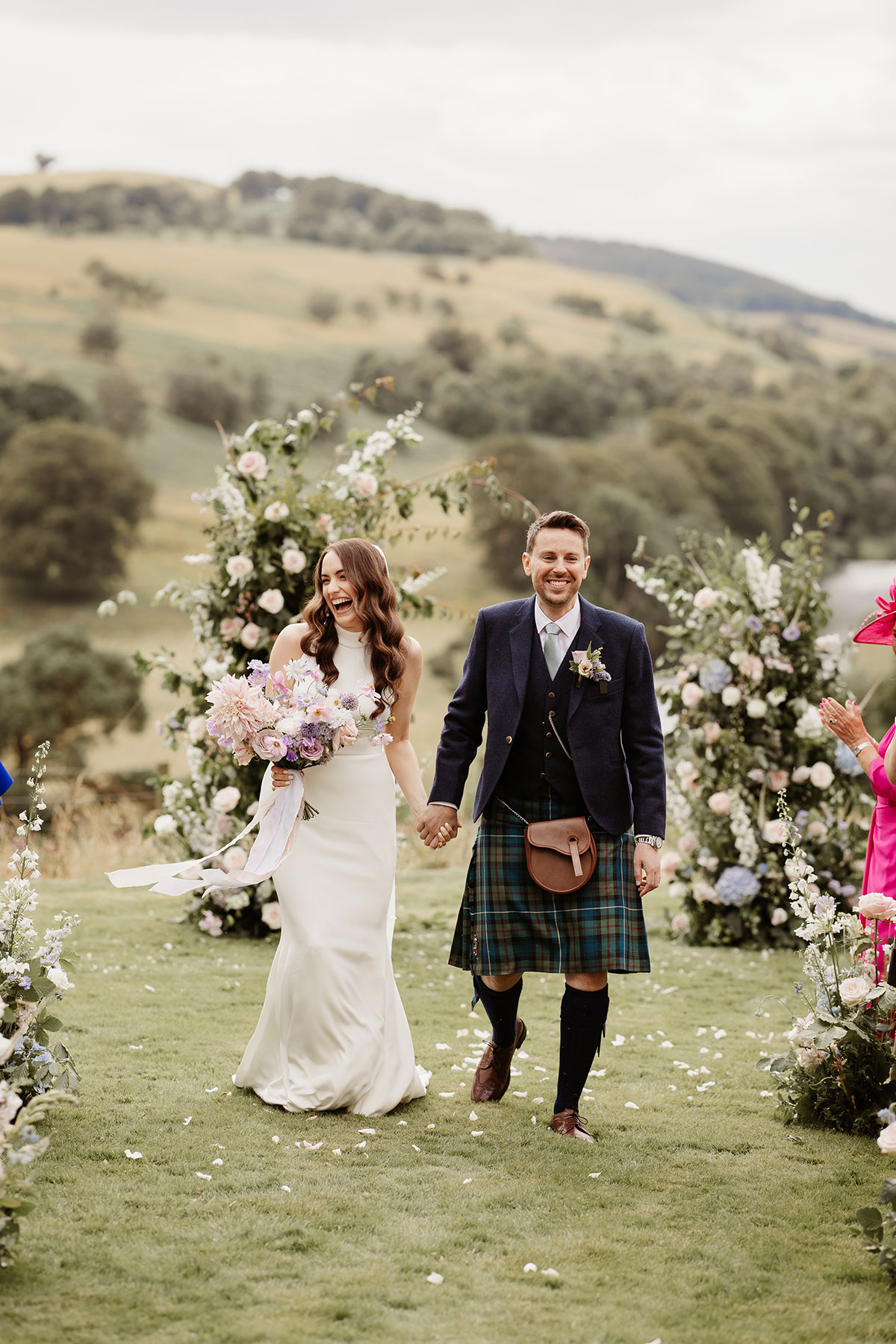 a bride and groom walking holding hands after outdoor wedding ceremony at Netherdale House