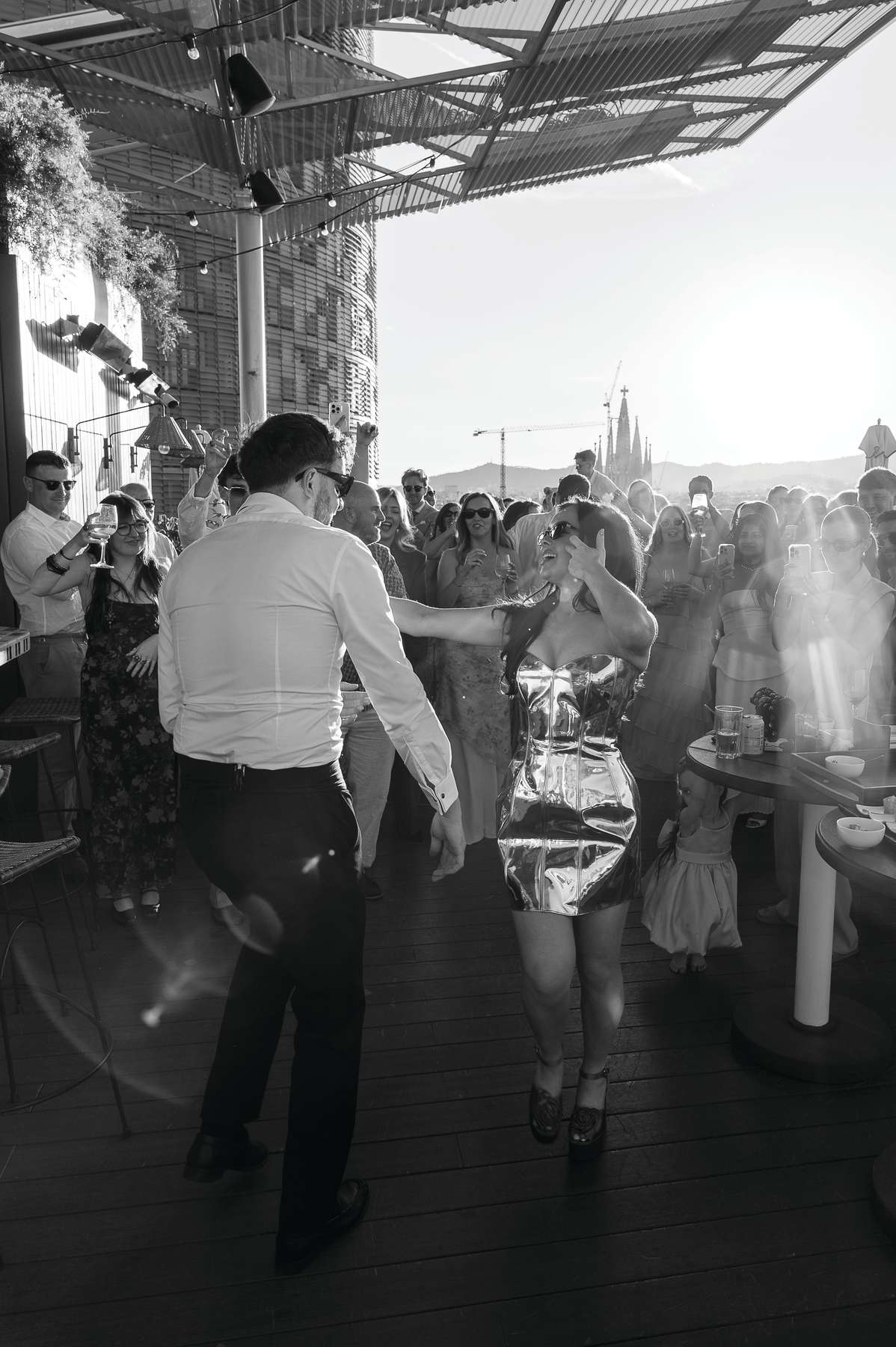 Bride and groom dance together surrounded by guests at their rooftop wedding party at The Hoxton Barcelona.