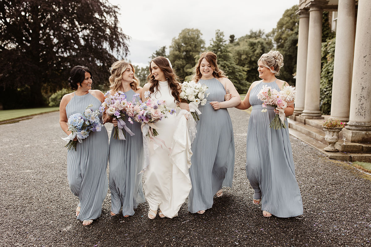 a bride and four bridesmaids walking outside Netherdale House