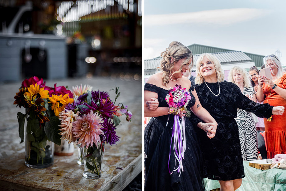 orange and purple dahlia flowers in small glass jars sitting on a wooden table on left and a bride wearing black holding hands with a person wearing a black mini dress on right