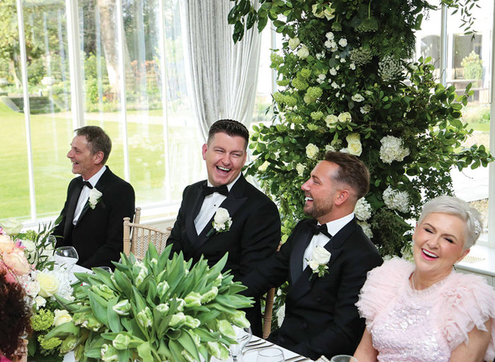 people seated at a long table laughing