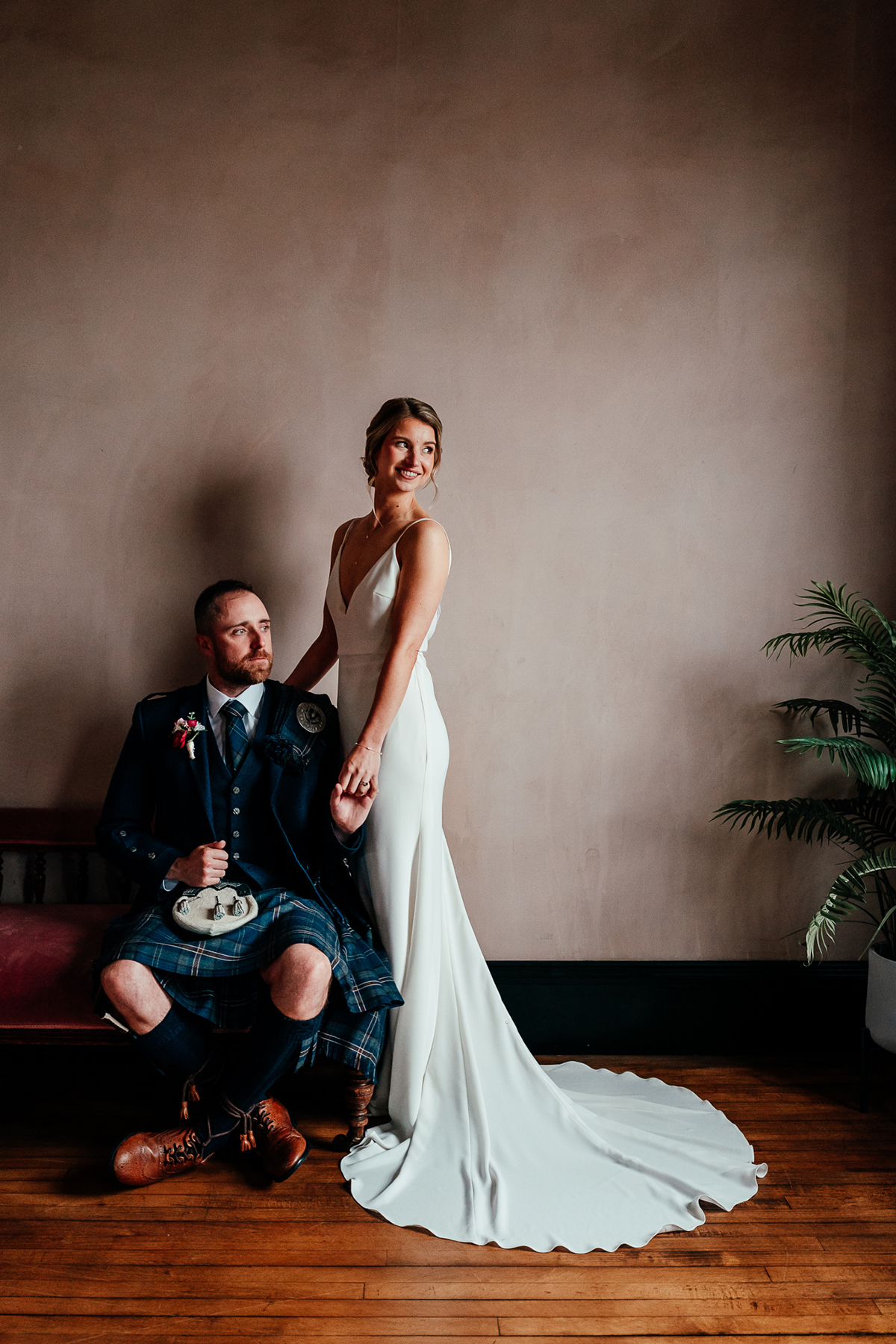 Bride and groom portrait inside The Engine Works Glasgow with neutral wall and wooden flooring