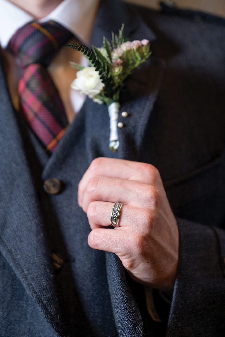 a silver celtic wedding ring and buttonhole