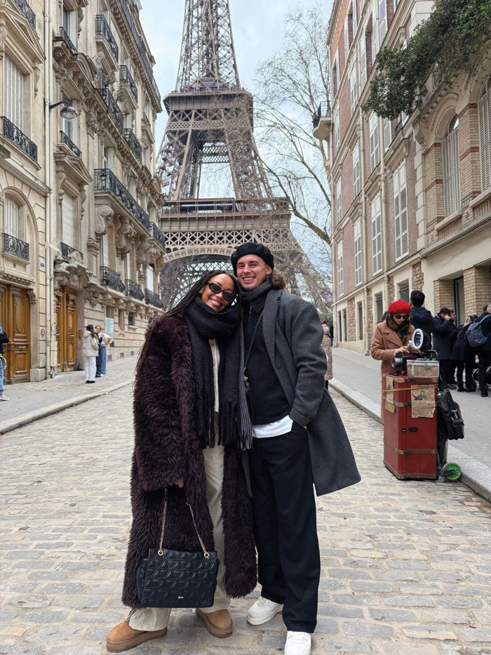 couple stand in front of eiffel tower in paris 