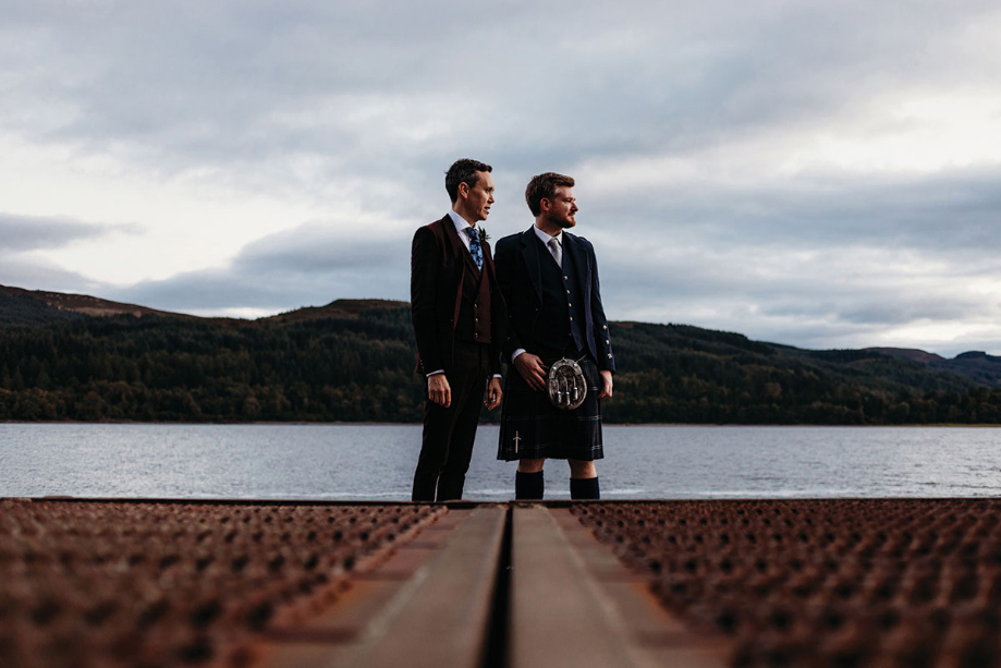 Newlywed portraits of grooms with loch views in the background