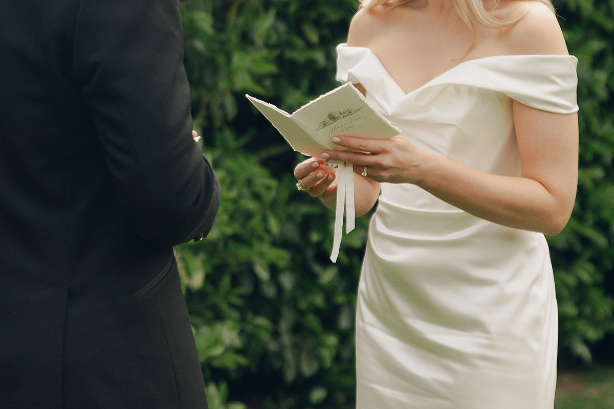Close-up of bride reading vows during outdoor ceremony at Gilmerton House East Lothian