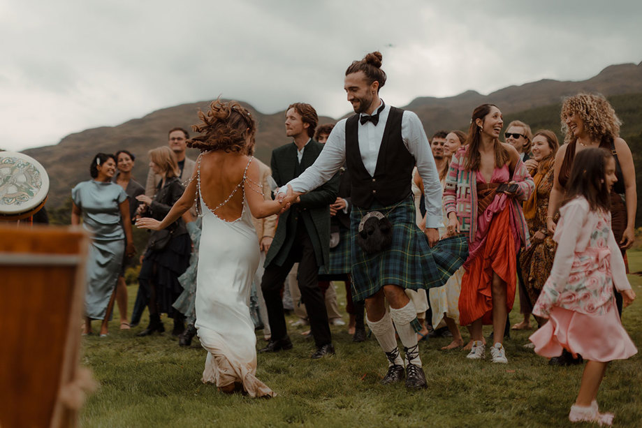 outdoor wedding ceilidh of bride and groom dancing at Carrick Castle Estate