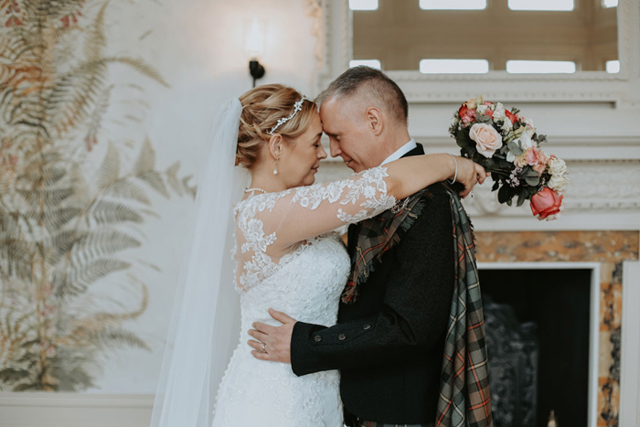 Bride and groom touch their foreheads together in couple photo
