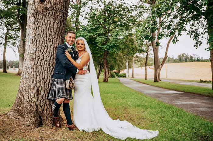A couple pose by a tree at their Enterkine House Wedding By Daryl Beveridge Photography