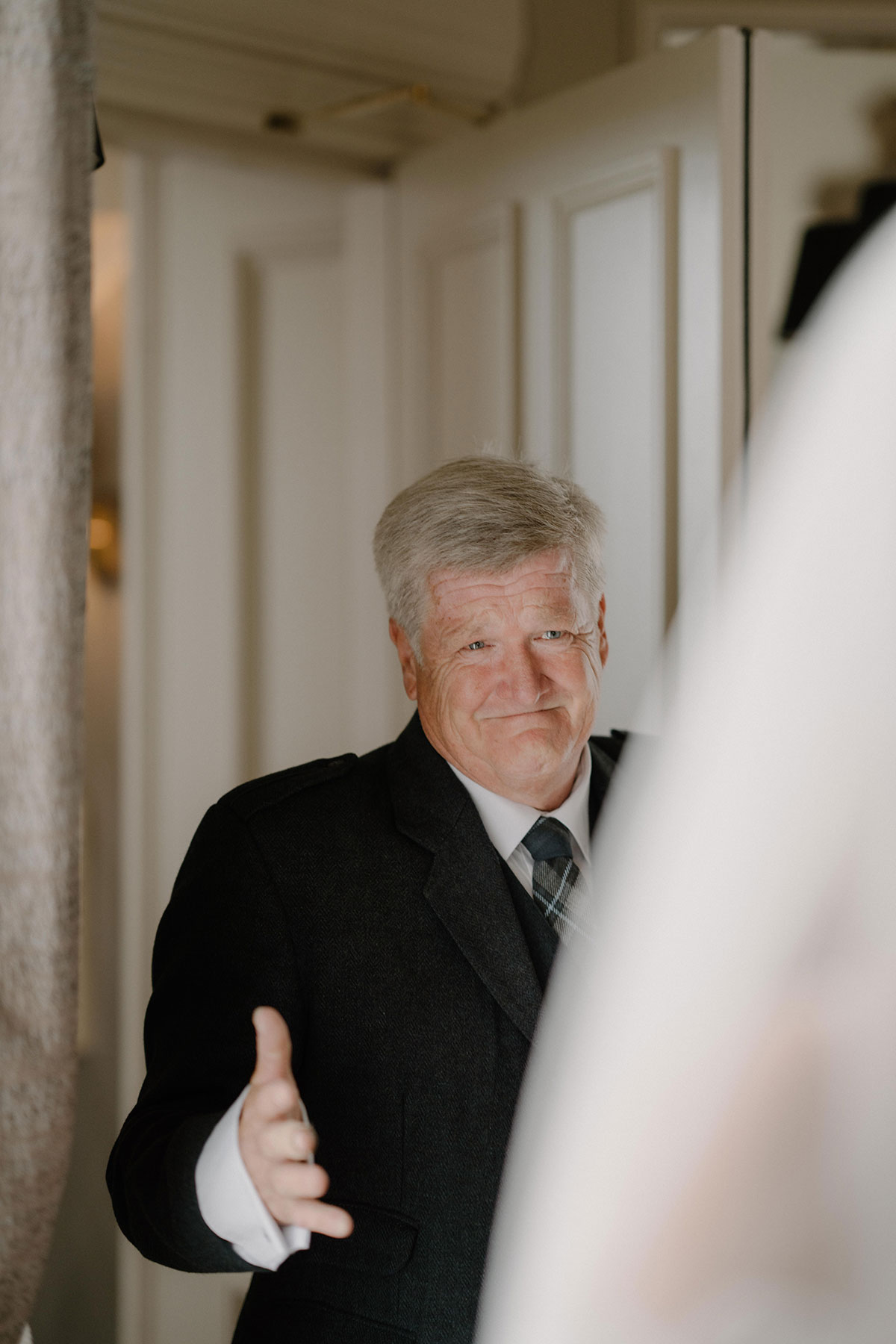 father of the bride looks emotional as he sees bride for the first time who is out of focus
