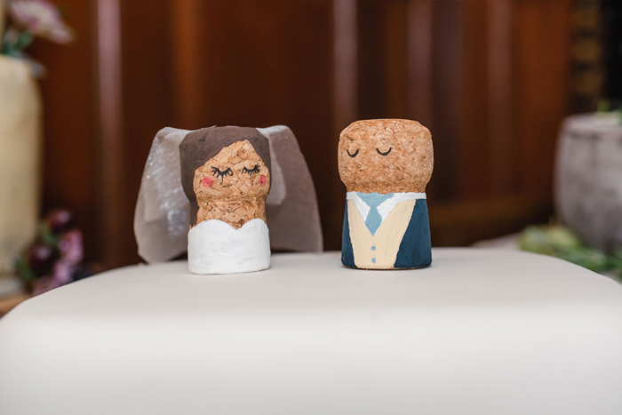 Cake topper of painted bride and groom corks