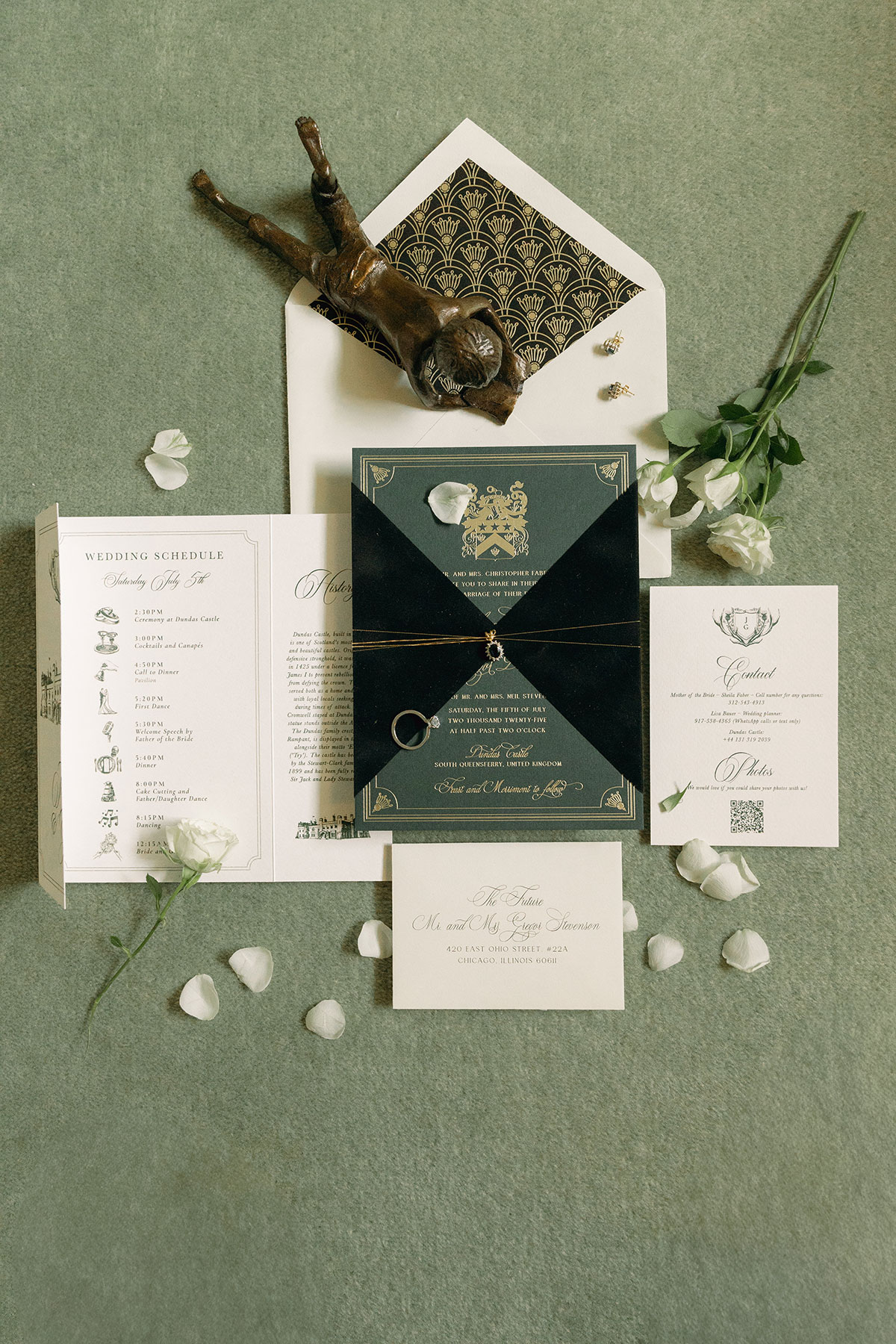 Flat lay of black and gold wedding stationery suite featuring crest and elegant typography at Dundas Castle wedding.