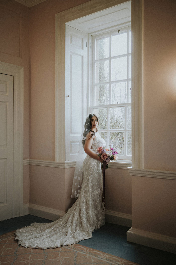 bride standing at window looking towards camera Chatelherault styled shoot