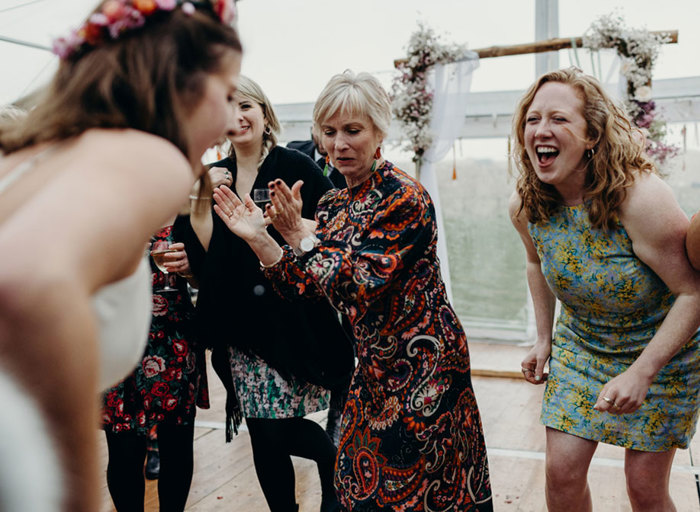 wedding guests in a marquee dancing and cheering