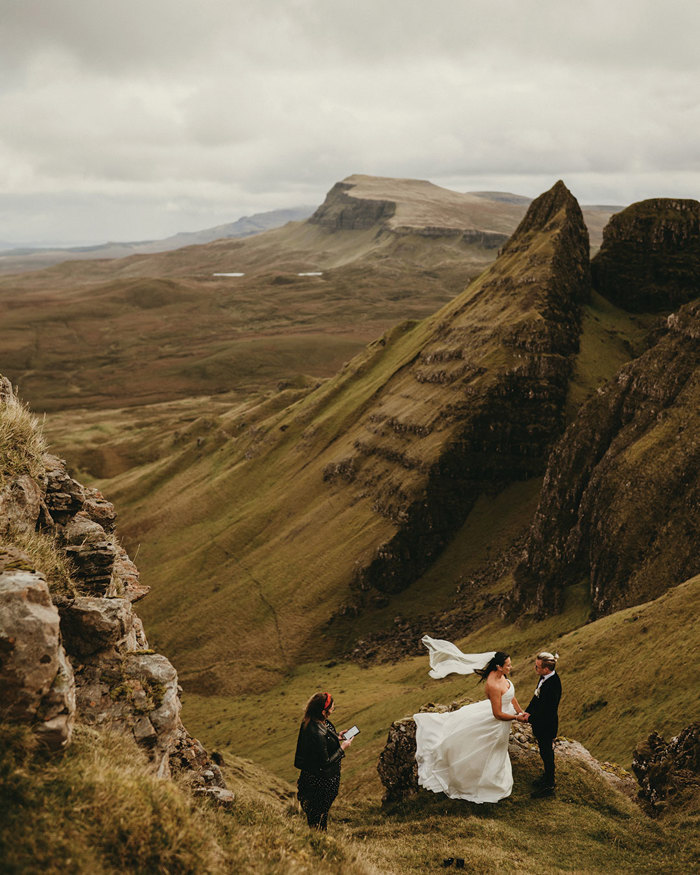 bride and groom say their marriage vows on top of a scottish mountain as a humanist celebrant conducts the ceremony