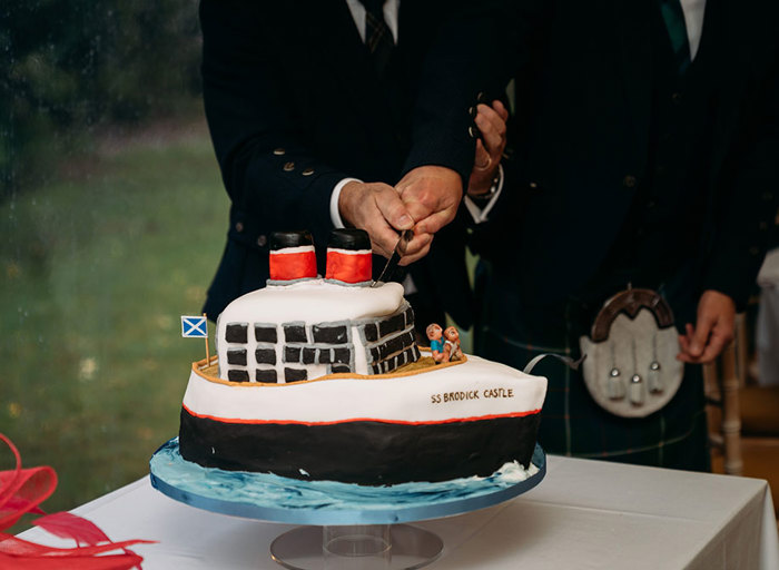 a homemade black, white and red wedding cake in the shape of a large passenger boat 