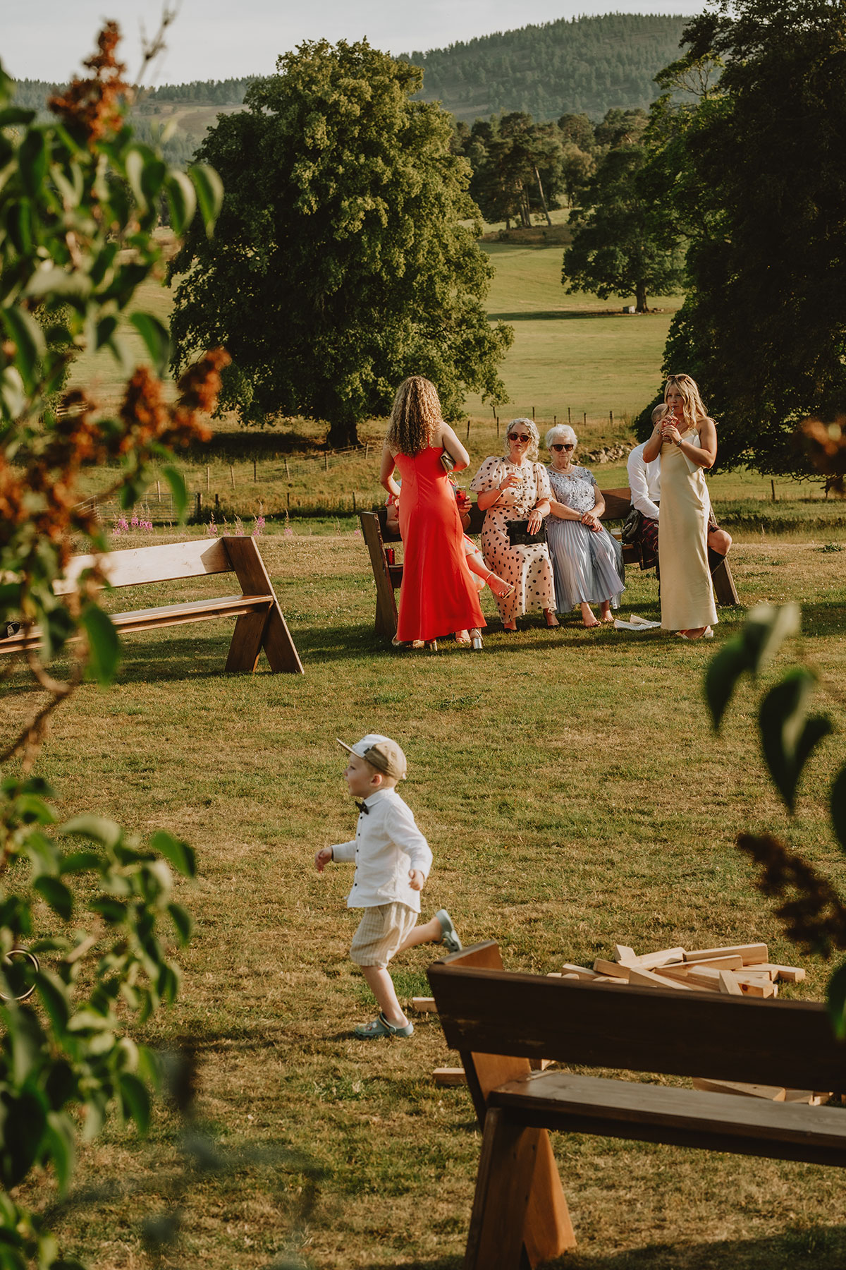 Wedding guests relaxing outdoors on the lawn at Ballogie Estate during a summer celebration