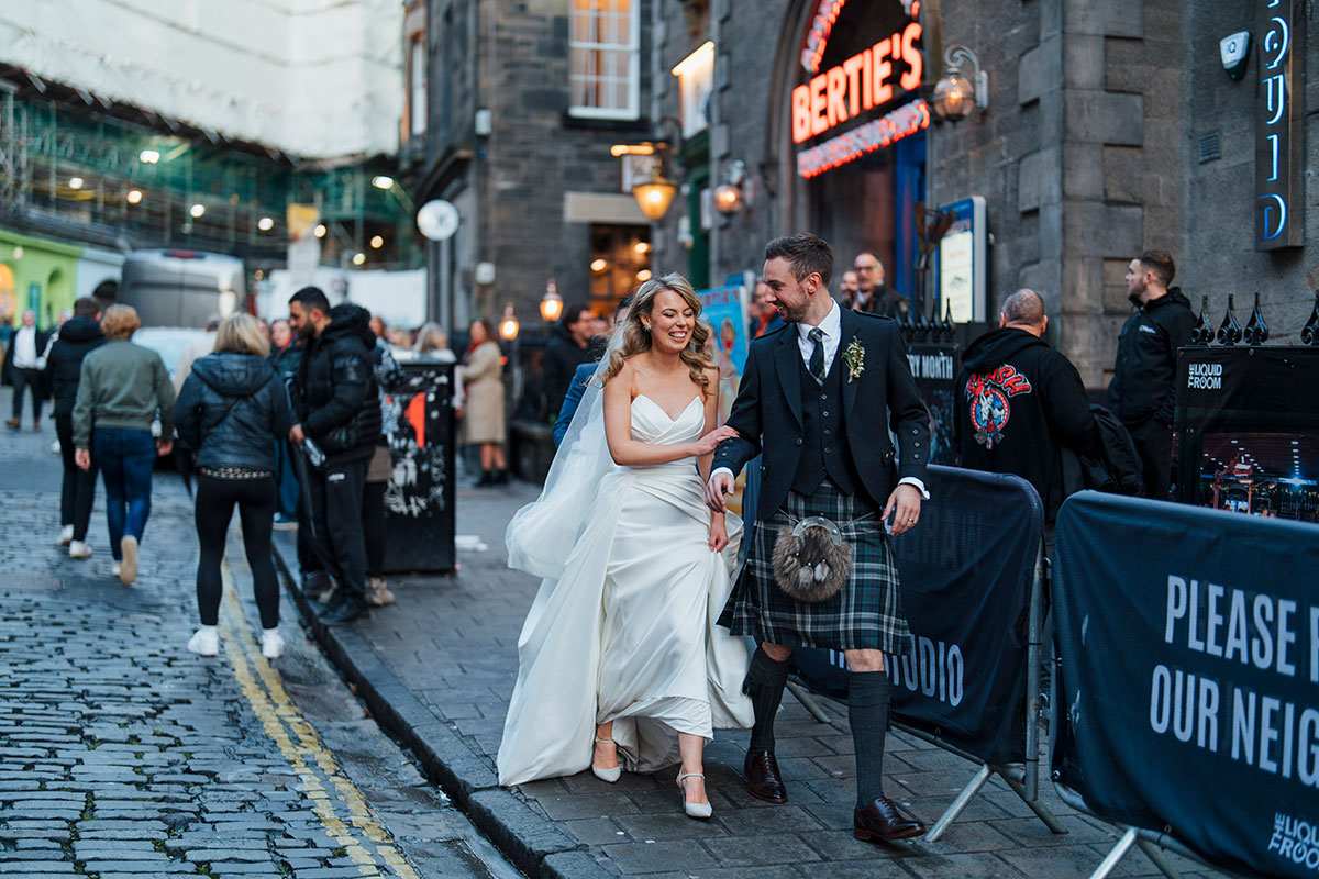 couple walking through Edinburgh on their wedding day at Virgin Hotels Edinburgh
