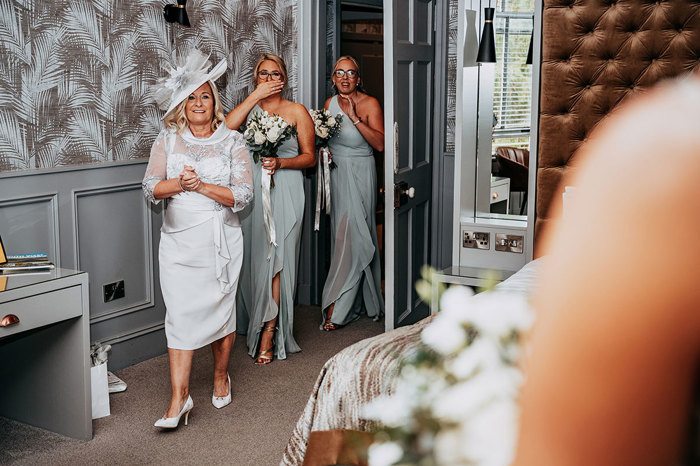 Bride reveals wedding dress to mother and two bridesmaids