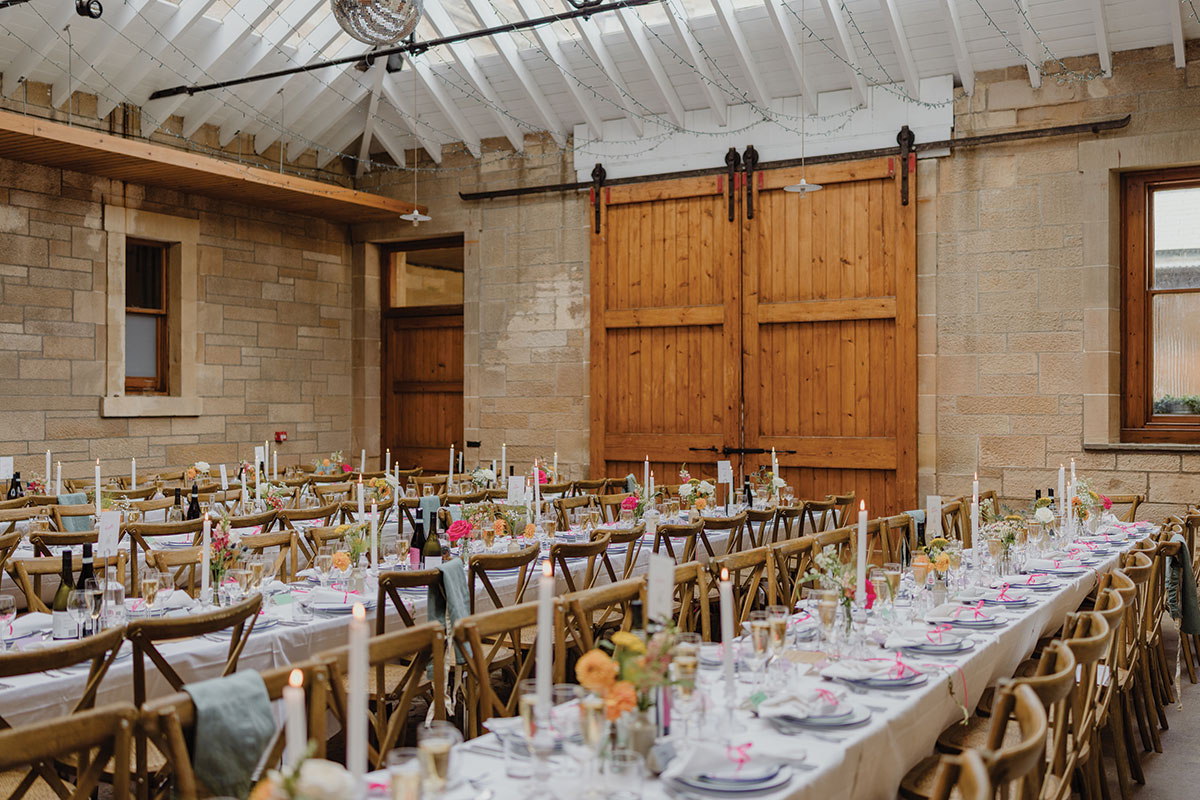Wedding breakfast setup in Cambo Estate courtyard with long tables, candles and floral styling