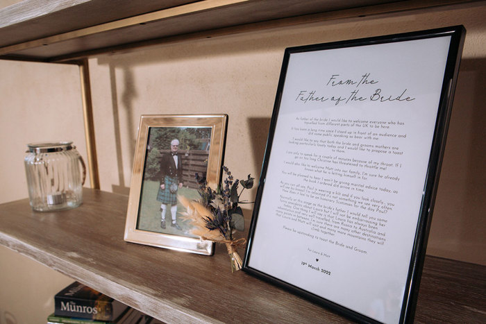 Framed pictures on shelf of Father of the Bride and a welcome letter from him